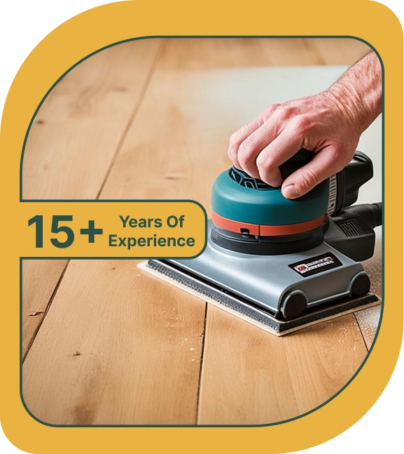 Person using electric sander on wooden floor.