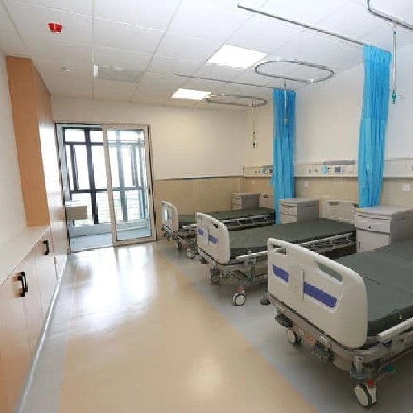 Polished vinyl floor in a hospital ward with beds and blue privacy curtains.