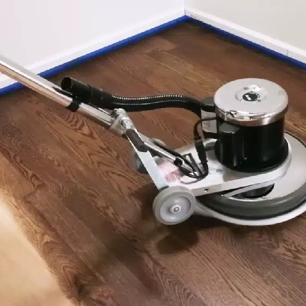orbital floor buffer polishing a dark-stained wood floor